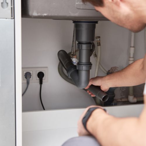 Handyman carrying out minor plumbing repairs in a Chelsea home